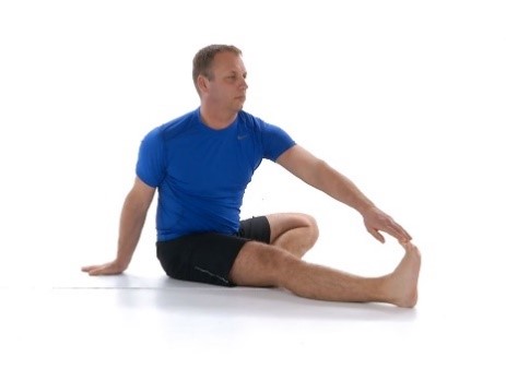 A man doing a seated hamstring stretch
